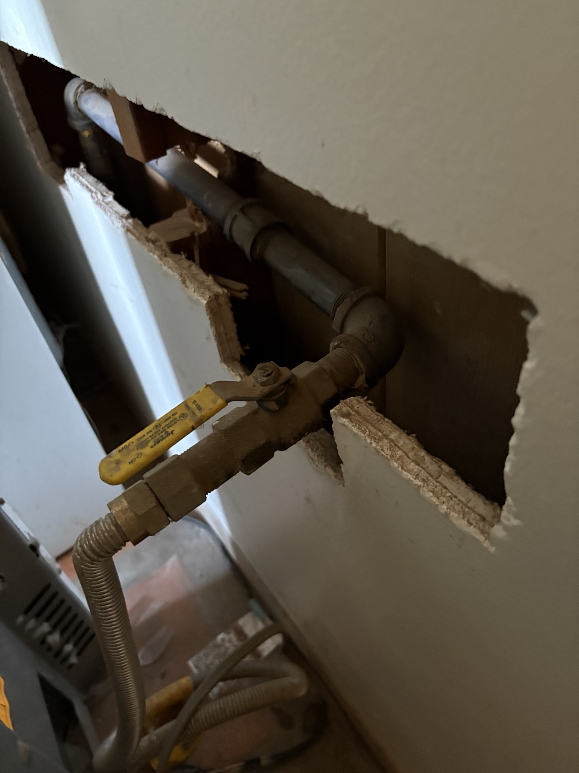 Accessible plumbing piping and shutoff exposed for repair