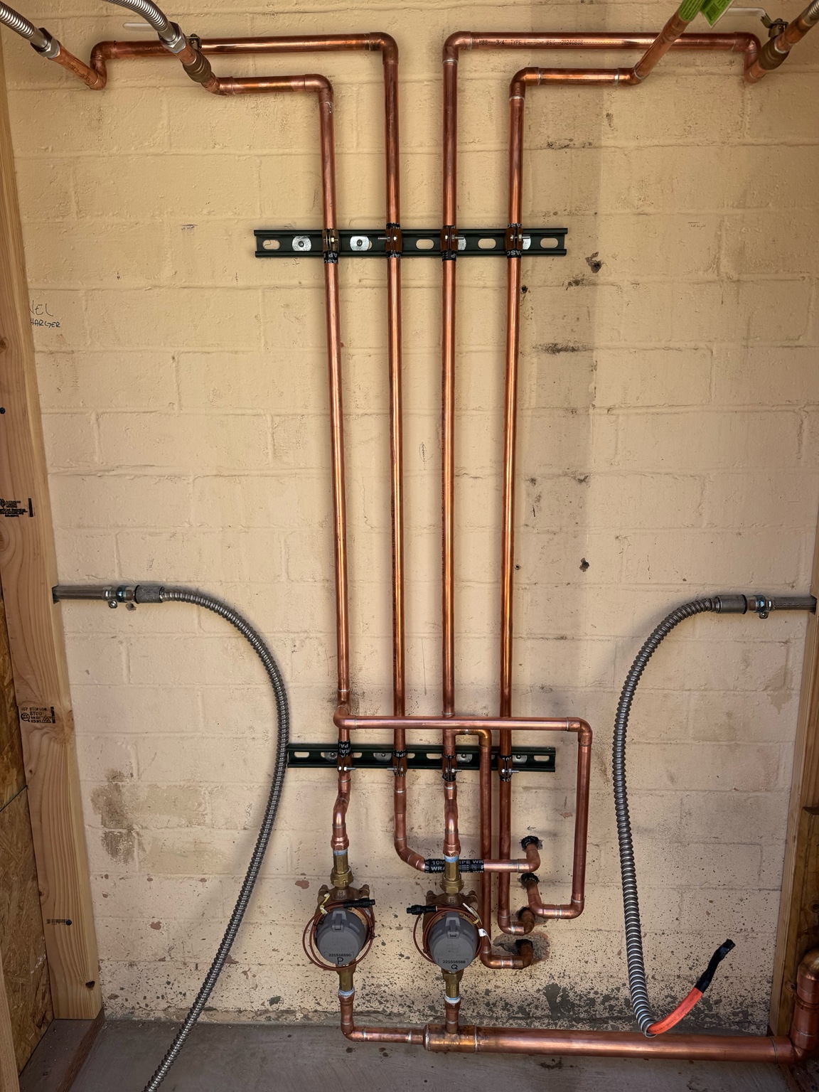 Dual water meters connected to supported copper distribution piping installed by Oasis Plumbing Solutions