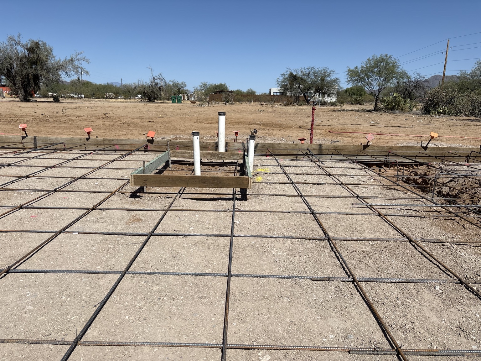 Plumbing rough-ins installed through a reinforced concrete foundation for new construction in Tucson